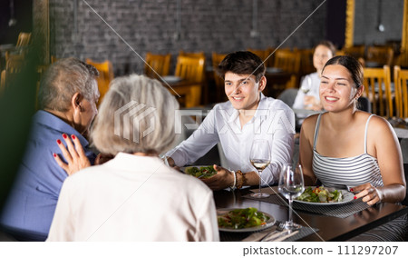 Elderly couple and young couple having dinner in restaurant 111297207