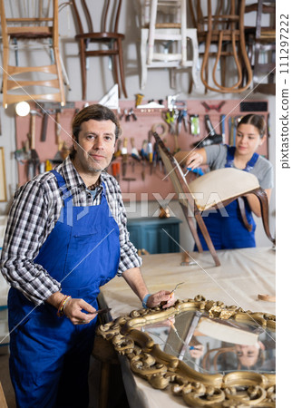 collected male restorer carefully covers carved wooden frame of antique mirror with layer of varnish collected male restorer carefully covers carved wooden frame of antique mirror with layer of varnish 111297222