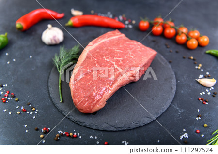 Raw fresh marbled meat and seasonings on dark background top view 111297524