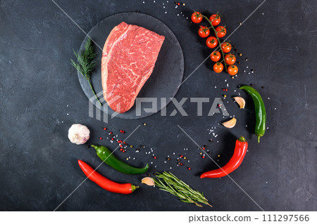 Raw fresh marbled meat and seasonings on dark background top view 111297566