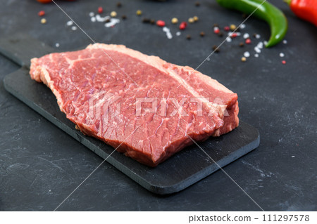 Raw fresh marbled meat and seasonings on dark background 111297578