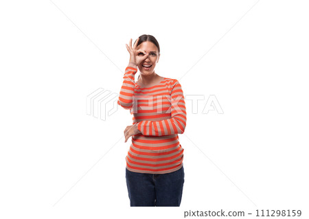 young pleasant caucasian woman with black hair dressed in a striped orange sweater posing on a white young pleasant caucasian woman with black hair dressed in a striped orange sweater posing on a white 111298159