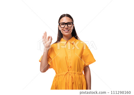 a young well-groomed woman with black straight hair dressed in a yellow dress smiles affably at the 111298160