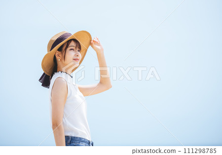 藍天下戴草帽的年輕女子 111298785