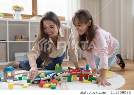Mother and little daughter playing together in nursery 111299086