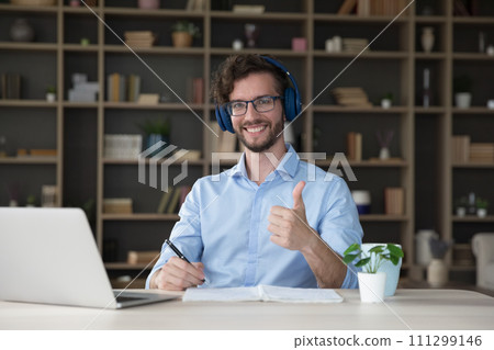 Man learner sit at desk with laptop showing thumb up Man learner sit at desk with laptop showing thumb up 111299146