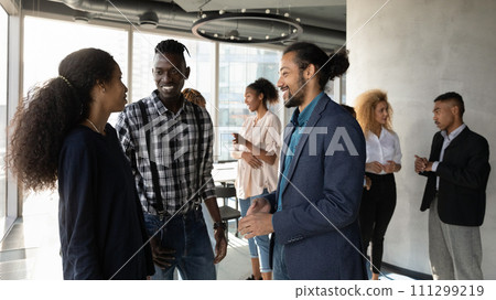 Smiling black male manager talk to clients at office space Smiling black male manager talk to clients at office space 111299219