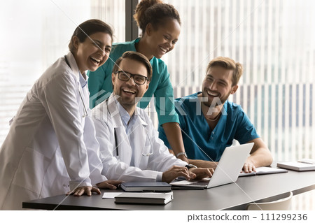 Group of cheerful diverse doctors laughing at laptop 111299236