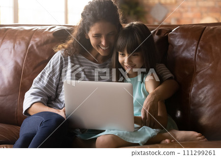 Young nanny and little girl friends use laptop at home Young nanny and little girl friends use laptop at home 111299261