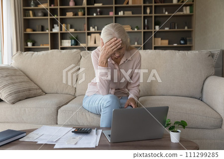 Upset senior woman check domestic expenditures feels stressed Upset senior woman check domestic expenditures feels stressed 111299285