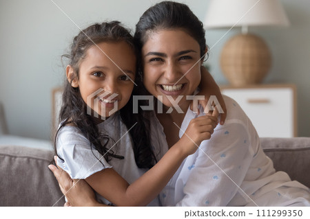 Indian woman and preschooler daughter cuddling posing looking at camera Indian woman and preschooler daughter cuddling posing looking at camera 111299350