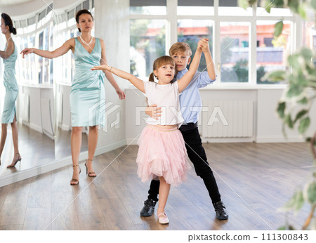 Boy and girl train to dance contemporary vigorous rumba during classes. 111300843