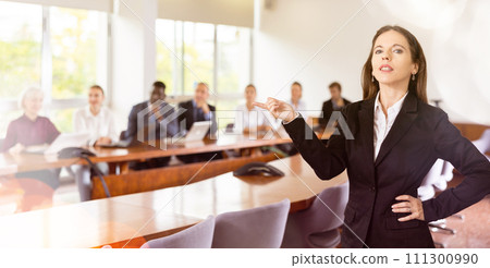 Portrait of an ambitious young businesswoman in meeting room against backdrop of team of her colleagues Portrait of an ambitious young businesswoman in meeting room against backdrop of team of her colleagues 111300990