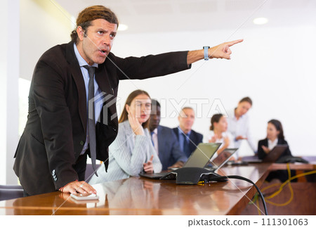 Businessman quarreling with colleagues during meeting 111301063