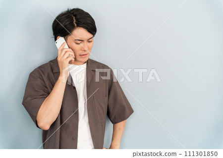 一個男人在智慧型手機上說話（不滿、不滿、負面、抱怨、壓力、憤怒） 111301850