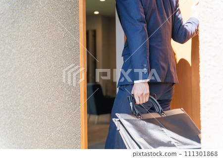 Male businessman in a suit opening the front door of his home (no face) Male businessman in a suit opening the front door of his home (no face) 111301868