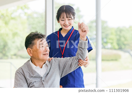 A female physical therapist/nurse (hand therapy/occupational therapist) giving rehabilitation guidance to an elderly man A female physical therapist/nurse (hand therapy/occupational therapist) giving rehabilitation guidance to an elderly man 111301906