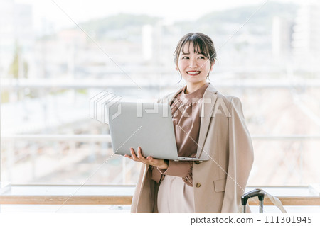 A woman/businesswoman using a computer at a station/terminal 111301945