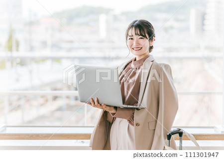 A woman/businesswoman using a computer at a station/terminal A woman/businesswoman using a computer at a station/terminal 111301947