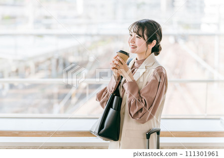 女商人在車站/航站樓入口處喝咖啡（會議、約會、等待、熱身） 111301961
