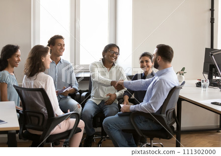 Confident cheerful Indian and Caucasian business colleagues shaking hands Confident cheerful Indian and Caucasian business colleagues shaking hands 111302000