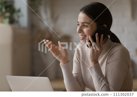 Pretty woman having pleasant conversation on cellphone at home Pretty woman having pleasant conversation on cellphone at home 111302037