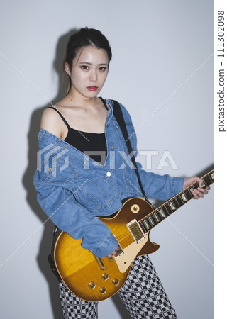 A woman playing the guitar 111302098