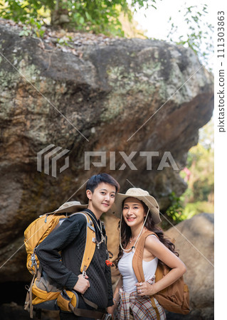 Lovely couple lesbian woman with backpack hiking in nature. Loving LGBT romantic moment in mountains 111303863