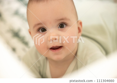 Baby boy on a bed smiling and happy. Close up portrait Baby boy on a bed smiling and happy. Close up portrait 111304660