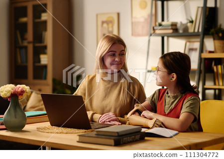 Clever amputee girl looking at tutor 111304772