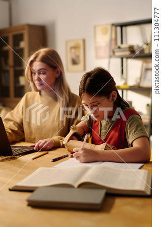 Girl with disability making notes 111304777