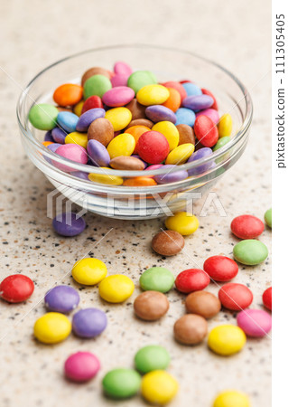 Colorful sweet candies in bowl on kitchen table. Colorful sweet candies in bowl on kitchen table. 111305405