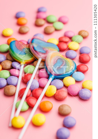 Colorful sweet jelly candies and lollipops. Sweet candies on pink background. 111305420