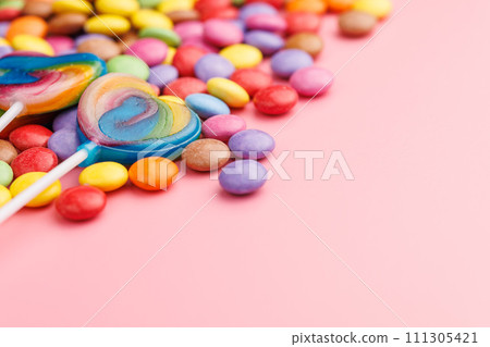Colorful sweet jelly candies and lollipops. Sweet candies on pink background. Colorful sweet jelly candies and lollipops. Sweet candies on pink background. 111305421