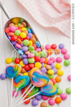 Colorful sweet jelly candies and lollipops. Sweet candies on white table. Colorful sweet jelly candies and lollipops. Sweet candies on white table. 111305423