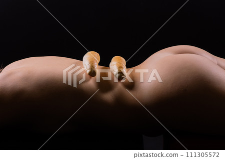 Female sensual body holding one big white bread bun with sesame seeds, horizontal picture Female sensual body holding one big white bread bun with sesame seeds, horizontal picture 111305572