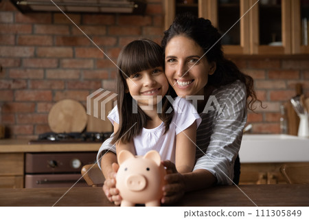 Thrifty latin mum and preteen kid save money in piggybank 111305849