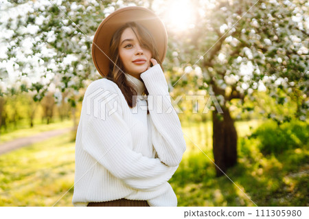 Beautiful young woman near blooming spring tree. Youth, love, fashion, romantic, lifestyle concept. Beautiful young woman near blooming spring tree. Youth, love, fashion, romantic, lifestyle concept. 111305980