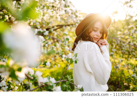 Beautiful young woman near blooming spring tree. Youth, love, fashion, romantic, lifestyle concept. Beautiful young woman near blooming spring tree. Youth, love, fashion, romantic, lifestyle concept. 111306025