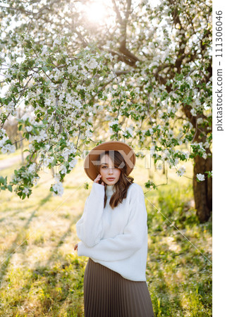 Beautiful young woman near blooming spring tree. Youth, love, fashion, romantic, lifestyle concept. Beautiful young woman near blooming spring tree. Youth, love, fashion, romantic, lifestyle concept. 111306046