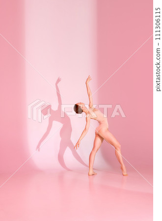 Blush Ballet. Young woman, ballerina, dancer in pink attire poses against pastel studio backdrop. Her shadow dances alongside her. 111306115