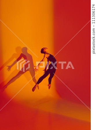 Athletic Beauty in Motion. Portrait of beautiful ballerina dances in black sports overalls, barefoot in neon-lit studio, her movements fluid against gradient background. Athletic Beauty in Motion. Portrait of beautiful ballerina dances in black sports overalls, barefoot in neon-lit studio, her movements fluid against gradient background. 111306174