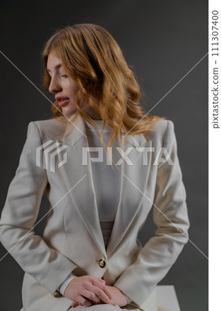 A Woman In A White Suit Is Sitting On A Stool A Woman In A White Suit Is Sitting On A Stool 111307400