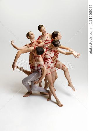 Talented artistic young people, man and women, ballet dancers performing, tied with red string, dancing against white studio background Talented artistic young people, man and women, ballet dancers performing, tied with red string, dancing against white studio background 111308055
