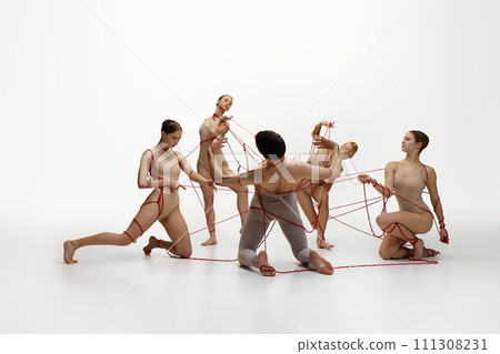 Maintenance of social life. Ballet dancers connected with red stings performing against white studio background 111308231
