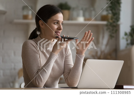 Young woman make call on speakerphone at home Young woman make call on speakerphone at home 111308985