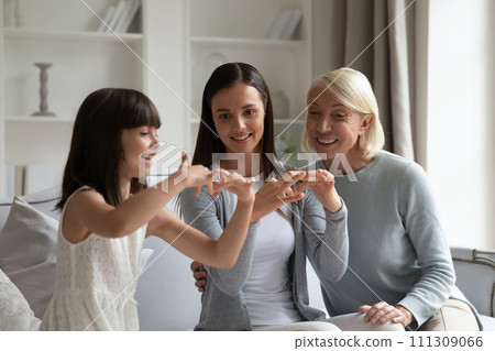 Smiling little girl with mother and grandmother practicing sign language Smiling little girl with mother and grandmother practicing sign language 111309066