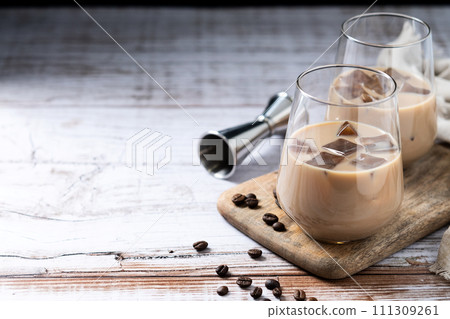 Traditional Irish cream coffee liqueur with ice on wooden table 111309261