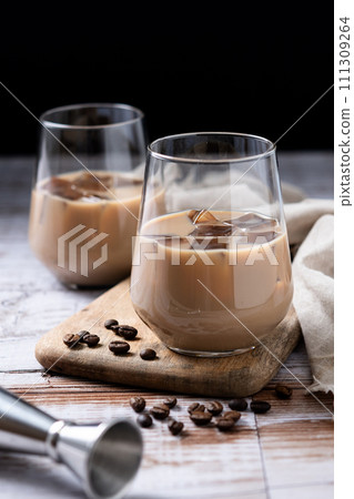 Traditional Irish cream coffee liqueur with ice on wooden table Traditional Irish cream coffee liqueur with ice on wooden table 111309264