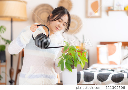 給室內植物澆水的大學女性 111309506